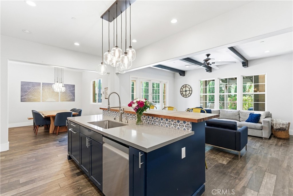 Open-concept kitchen and family room with oversized entertainer’s island, custom cabinetry, stacked-stone fireplace, and - 31491 Carril De Maderas, San Juan Capistrano CA 92675 - photo 18