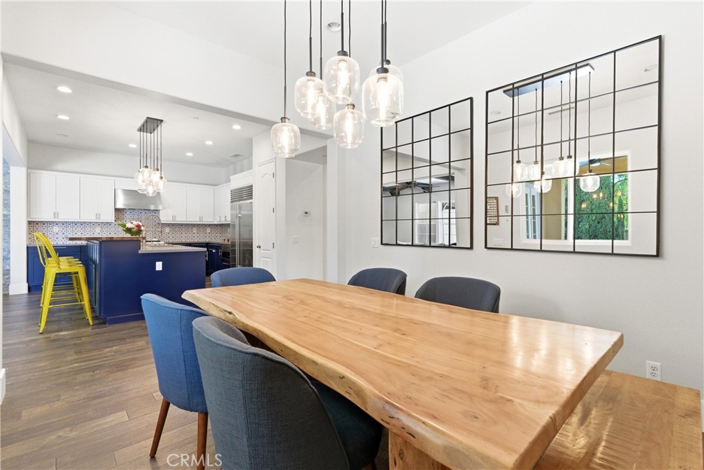 Open dining room with designer pendant lighting, wide-plank flooring, oversized windows, and contemporary entertaining s - 31491 Carril De Maderas, San Juan Capistrano CA 92675 - photo 22