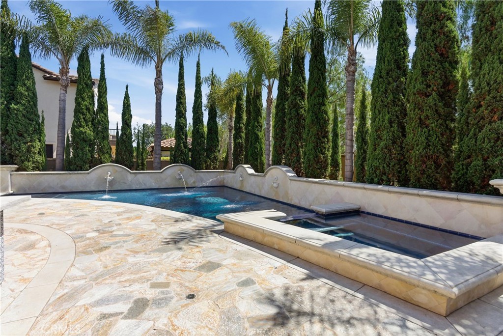 Resort-style backyard with sparkling pool, raised spa, water features, and expansive stone hardscape - 31491 Carril De Maderas, San Juan Capistrano CA 92675 - photo 26