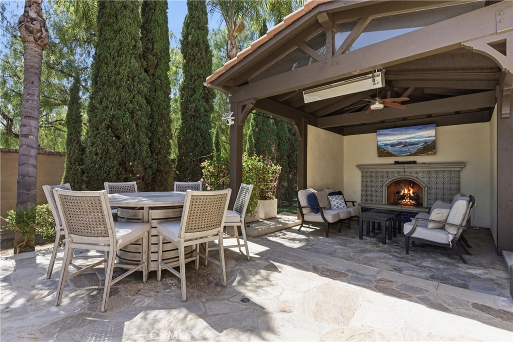 Covered outdoor lounge pavilion with custom fireplace, mounted TV, ceiling fan, and built-in heaters - 31491 Carril De Maderas, San Juan Capistrano CA 92675 - photo 31