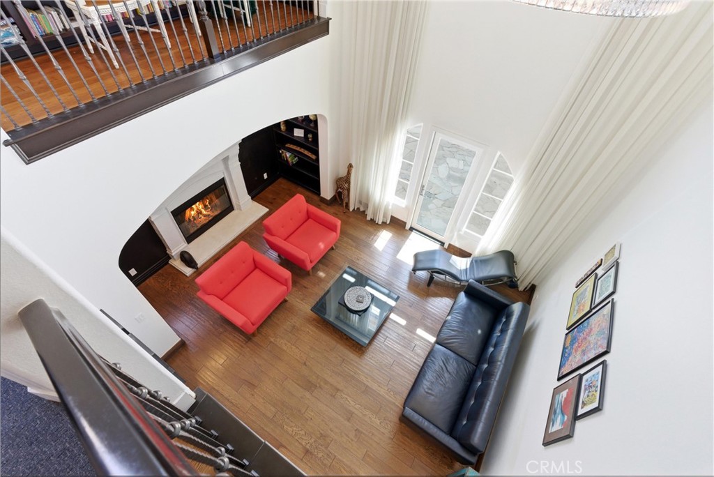Grand formal living space with soaring ceilings, fireplace, custom built-ins, and floor-to-ceiling windows that flood th - 31491 Carril De Maderas, San Juan Capistrano CA 92675 - photo 38