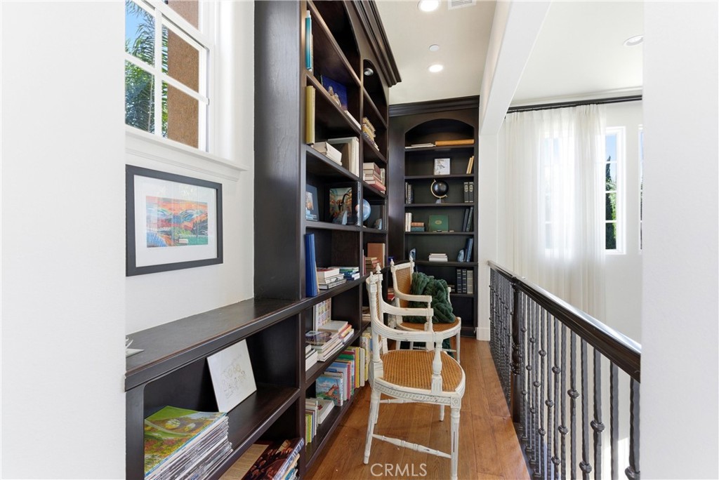 Upper-level library loft with custom built-in shelving overlooking the main living area, creating a refined space for re - 31491 Carril De Maderas, San Juan Capistrano CA 92675 - photo 39