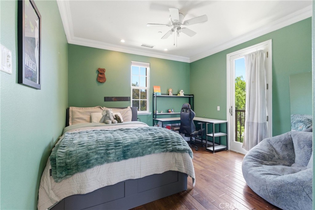 Versatile upstairs bedroom with green accent walls, hardwood flooring, study space, ceiling fan, and private balcony acc - 31491 Carril De Maderas, San Juan Capistrano CA 92675 - photo 61