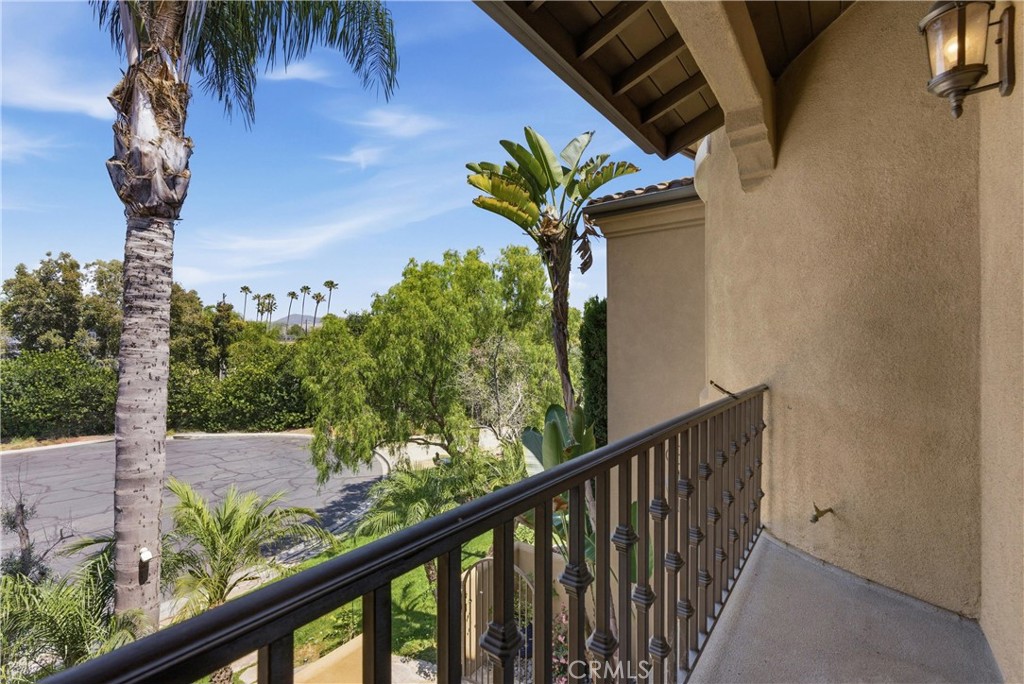 Private upper-level balcony overlooking mature landscaping, palm trees, and neighborhood views. - 31491 Carril De Maderas, San Juan Capistrano CA 92675 - photo 62