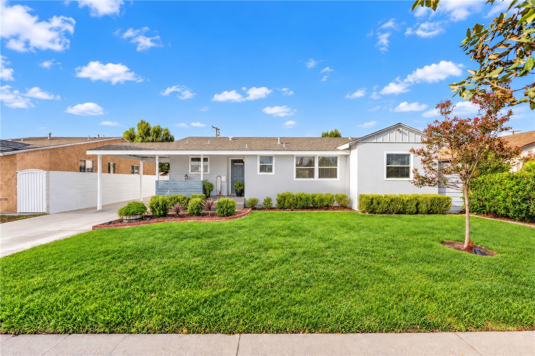 Single-story Riverview home pairs classic curb appeal with a lush front lawn, a welcoming covered porch, and a carport w - 1711 W 21st, Santa Ana CA 92706 - photo 3