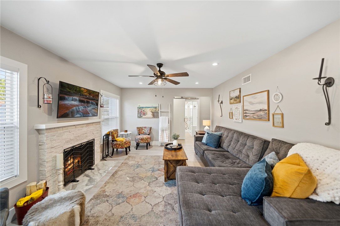Living room with fire place. Barn door leads to hallway with two beds and full bath. - 1711 W 21st, Santa Ana CA 92706 - photo 8