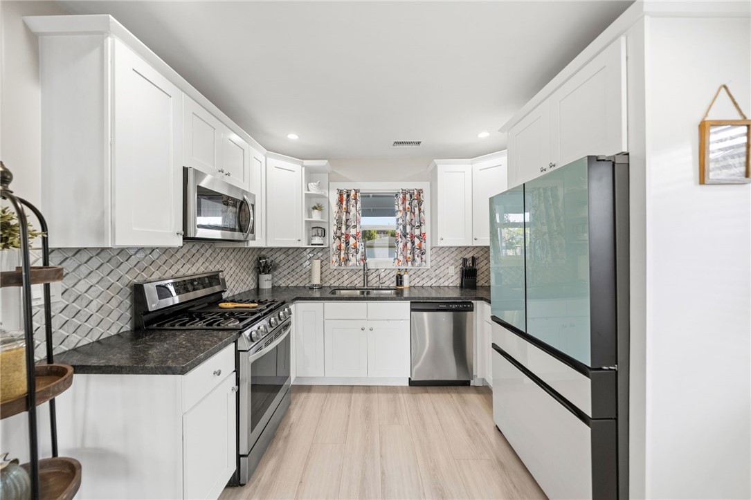 Upgraded kitchen, recessed lighting, white cabinets, smart appliances and osmosis water system. - 1711 W 21st, Santa Ana CA 92706 - photo 14
