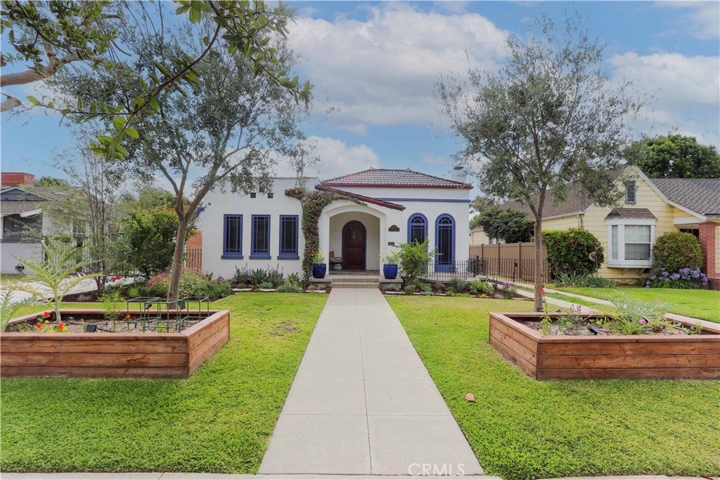Front yard with two raised beds for growing food and mature olive trees. - 2421 Oakmont, Santa Ana CA 92706 - photo 1