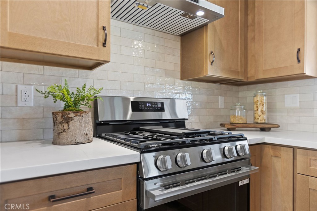 Fully remodeled kitchen with new cabinets, stainless appliances, and quartz counters, and tile backsplash - 3709 S Olive Street, Santa Ana CA 92707 - photo 13