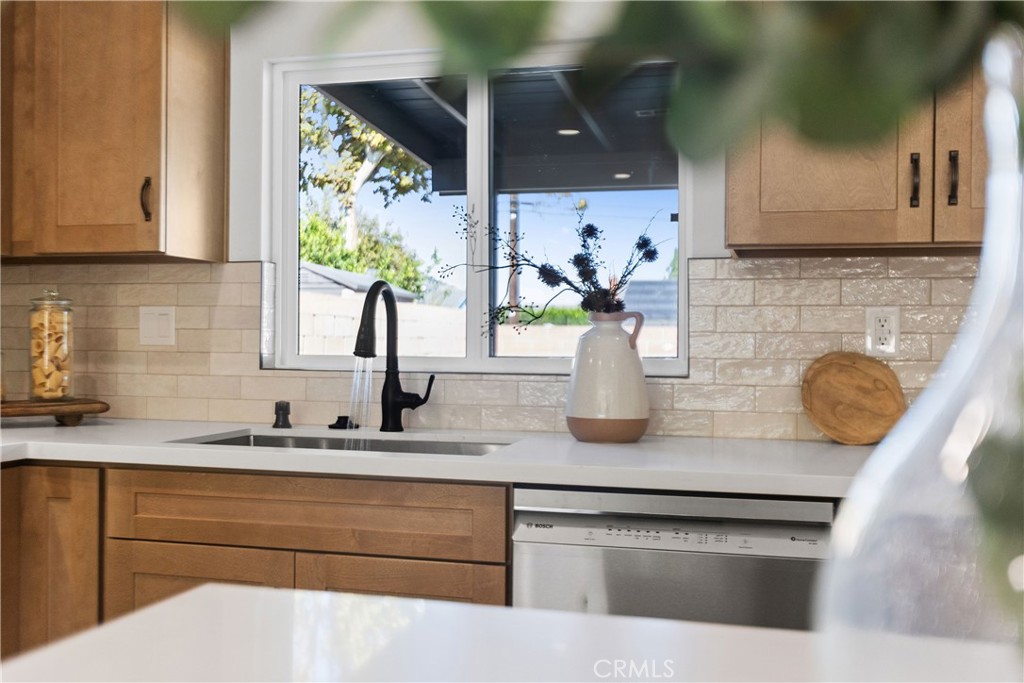 Fully remodeled kitchen with new cabinets, stainless appliances, and quartz counters, and tile backsplash - 3709 S Olive Street, Santa Ana CA 92707 - photo 14