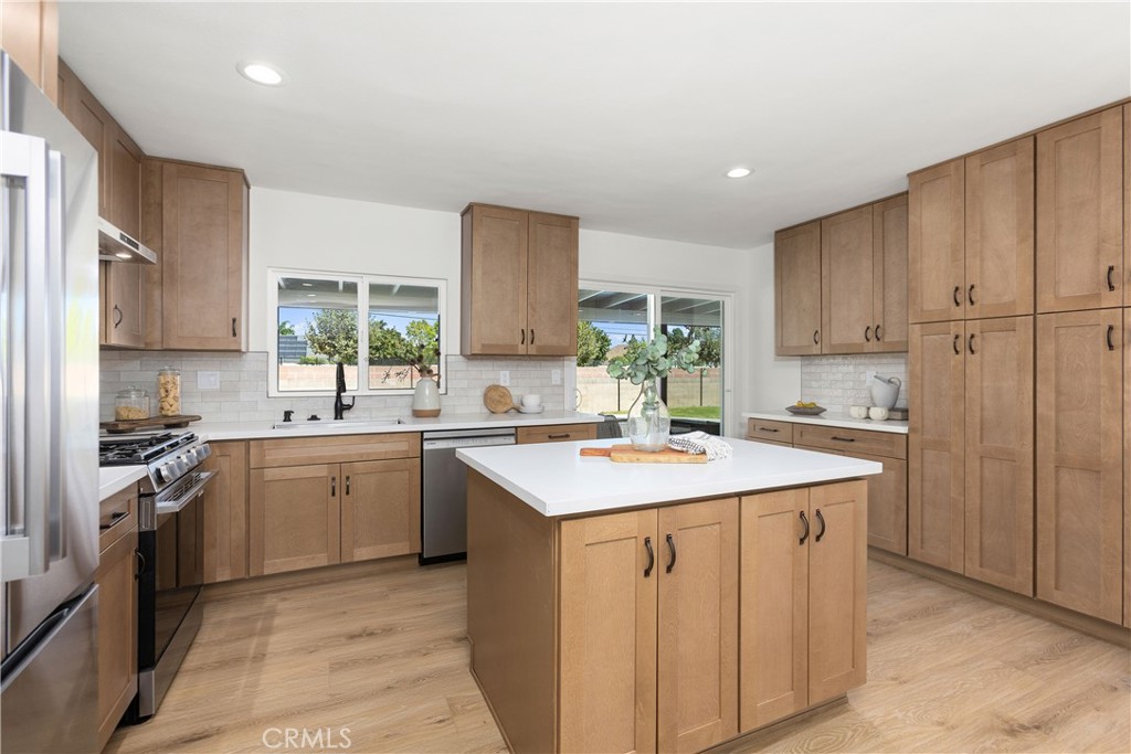 Fully remodeled kitchen with new cabinets, stainless appliances, and quartz counters, and tile backsplash - 3709 S Olive Street, Santa Ana CA 92707 - photo 16