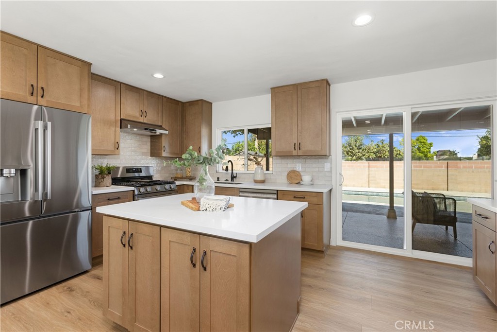 Fully remodeled kitchen with new cabinets, stainless appliances, and quartz counters, and tile backsplash - 3709 S Olive Street, Santa Ana CA 92707 - photo 17