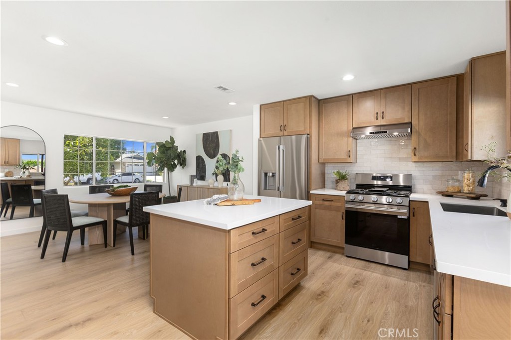 Fully remodeled kitchen with new cabinets, stainless appliances, and quartz counters, and tile backsplash - 3709 S Olive Street, Santa Ana CA 92707 - photo 18