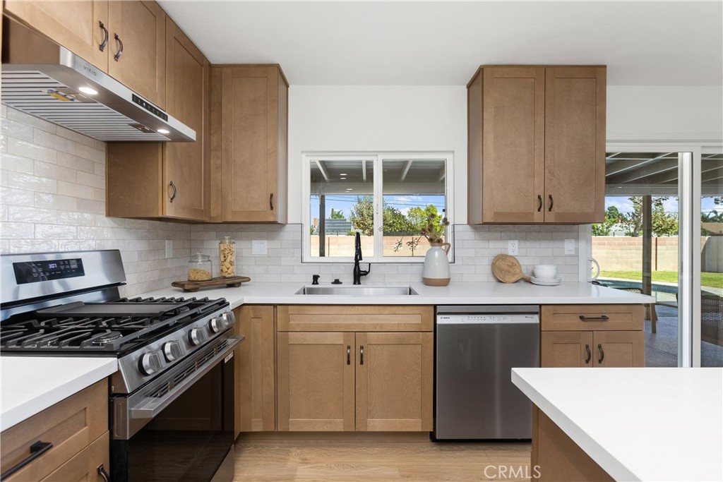 Fully remodeled kitchen with new cabinets, stainless appliances, and quartz counters, and tile backsplash - 3709 S Olive Street, Santa Ana CA 92707 - photo 19