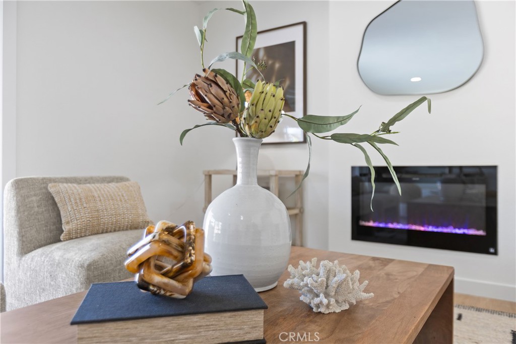 Living room with modern electric fireplace and direct access to outdoor patio and pool area - 3709 S Olive Street, Santa Ana CA 92707 - photo 22