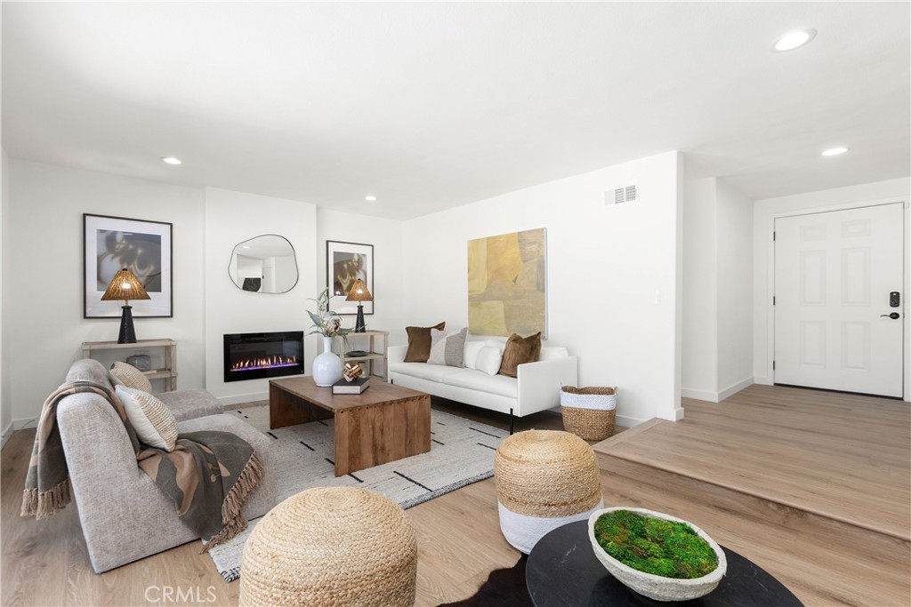 Living room with modern electric fireplace and direct access to outdoor patio and pool area - 3709 S Olive Street, Santa Ana CA 92707 - photo 24