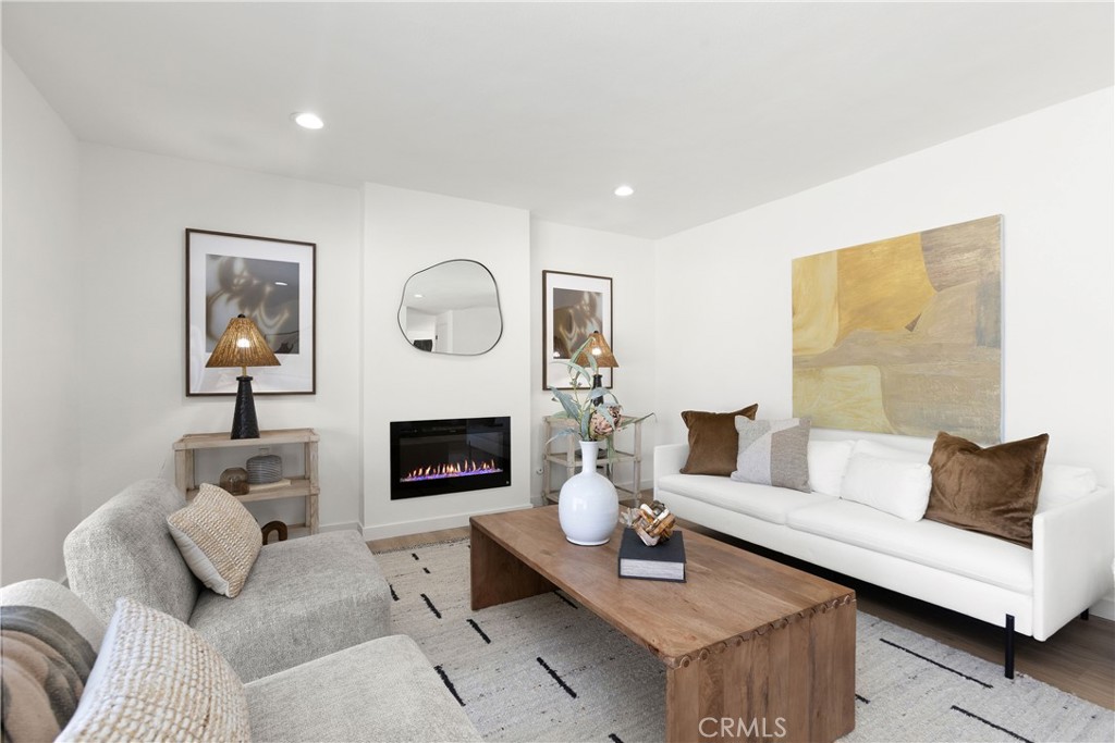 Living room with modern electric fireplace and direct access to outdoor patio and pool area - 3709 S Olive Street, Santa Ana CA 92707 - photo 25