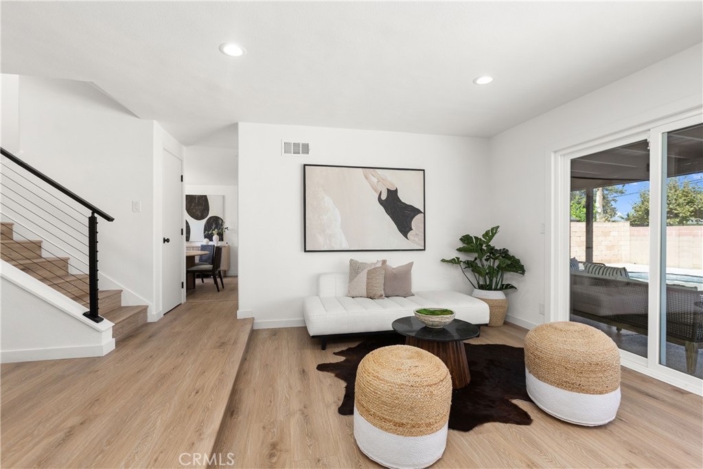 Living room with modern electric fireplace and direct access to outdoor patio and pool area - 3709 S Olive Street, Santa Ana CA 92707 - photo 28