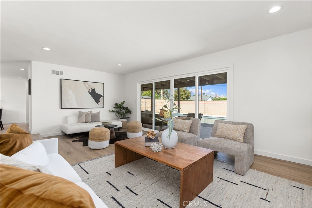 Living room with modern electric fireplace and direct access to outdoor patio and pool area - 3709 S Olive Street, Santa Ana CA 92707 - photo 29