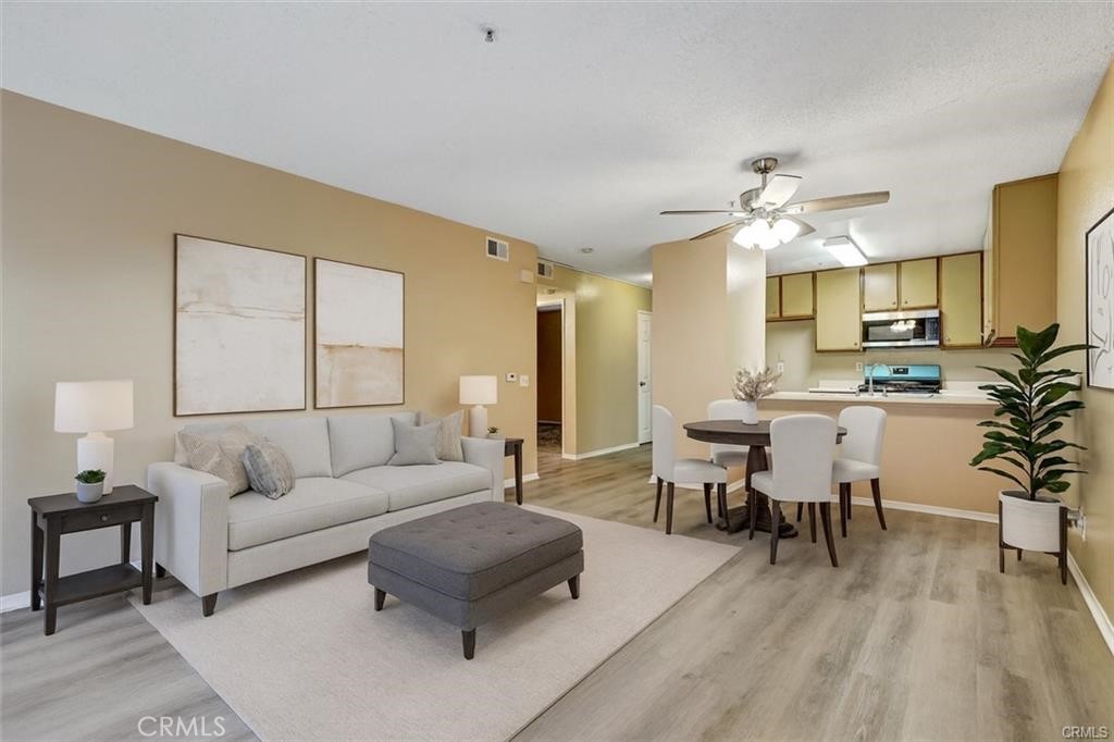 Spacious Living room opens to dining area_digital staged - 450 E 4th Street 334, Santa Ana CA 92701 - photo 1