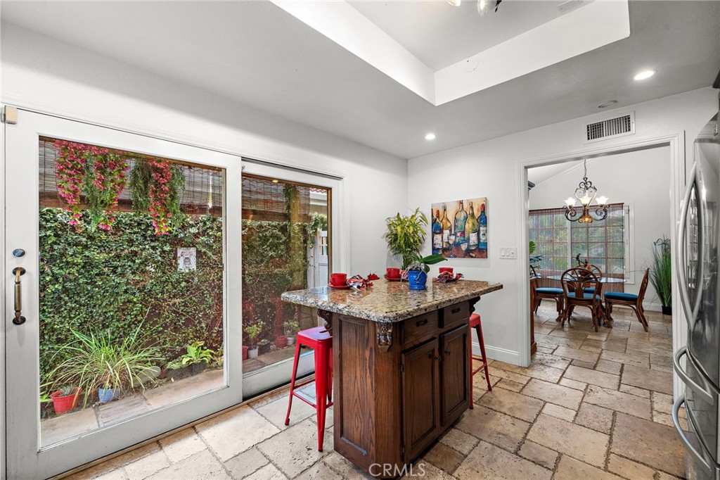 Kitchen Moveable Center Island with Breakfast Bar Seating and Sliding Glass Doors that Open to Side Yard - 622 W Alpine Avenue, Santa Ana CA 92707 - photo 11