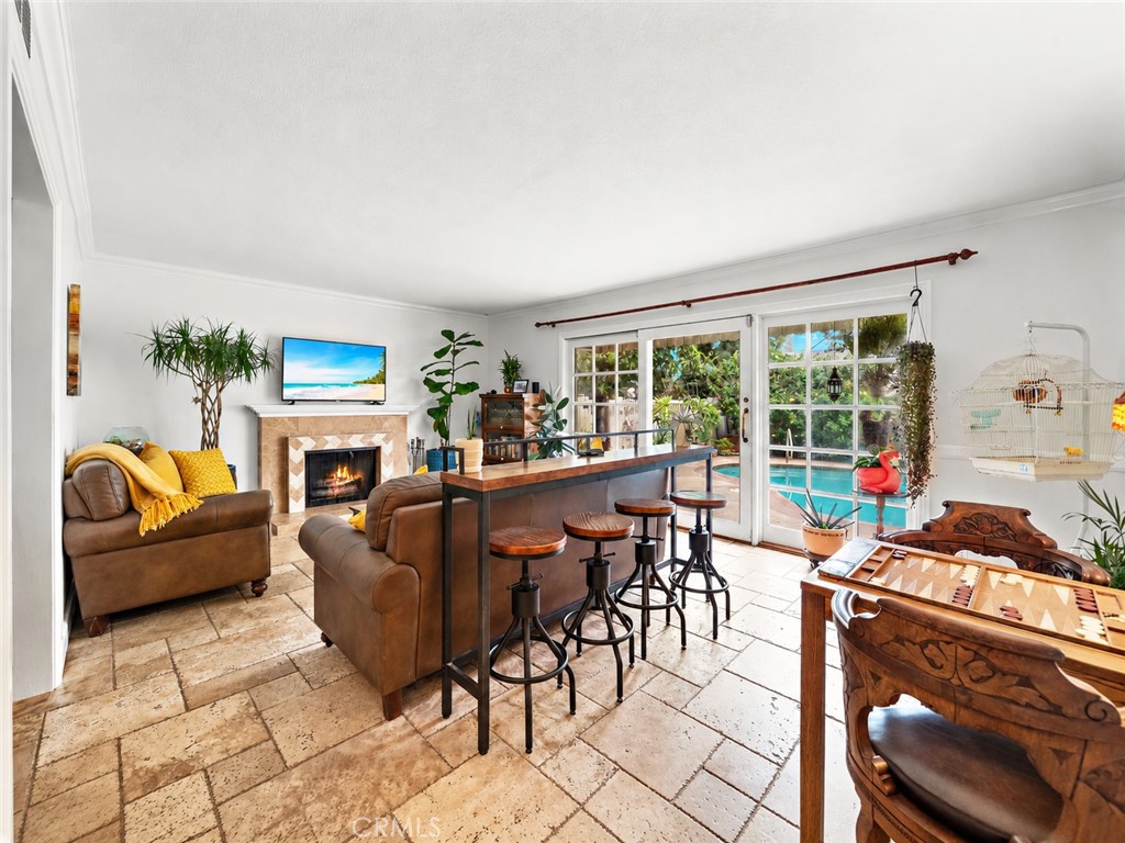 inviting Family Room with Travertine Flooring, Fireplace, Wet Bar, and Wall of French Sliders Leading to Resort Backyard - 622 W Alpine Avenue, Santa Ana CA 92707 - photo 14