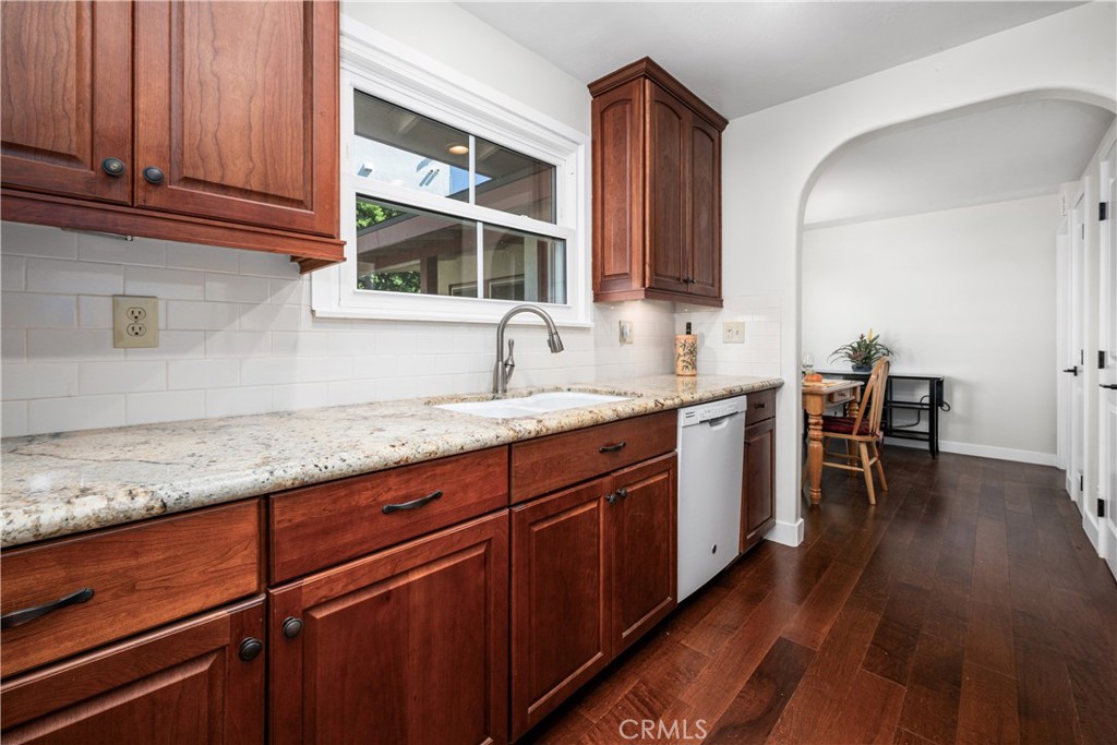 The galley kitchen has been remodeled with wood cabinets and granite counters. A window over the sink brings in light an - 1200 Catalina Avenue, Seal Beach CA 90740 - photo 13
