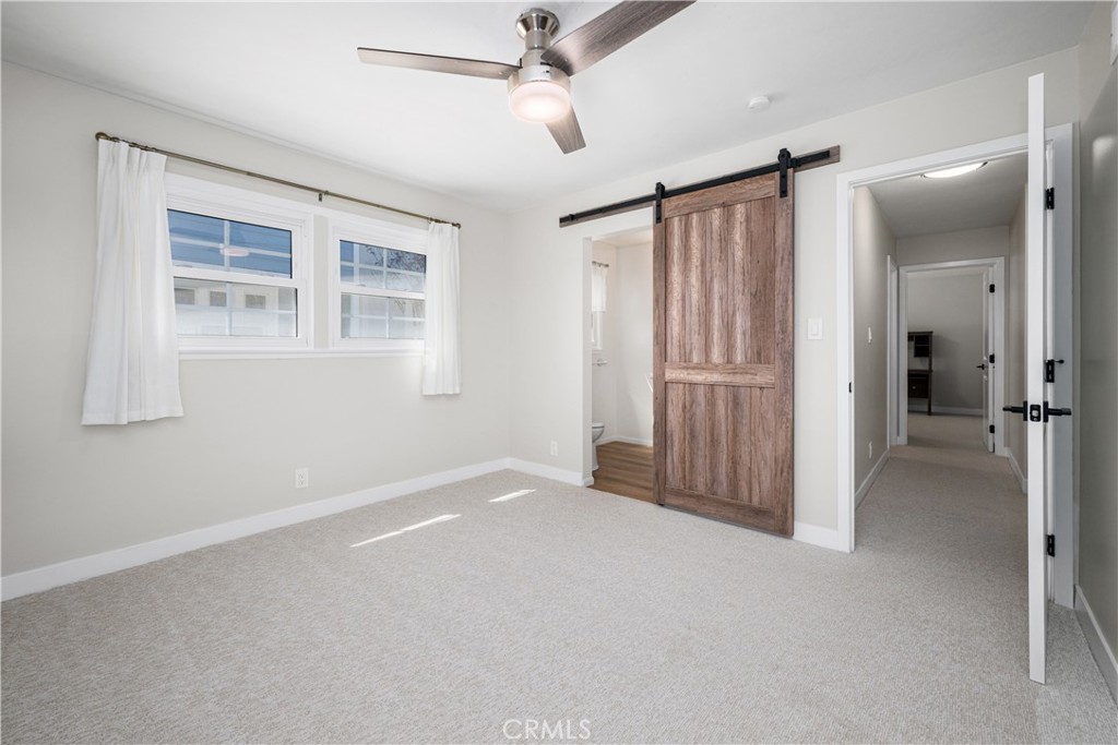 Main bedroom has been refreshed with new carpet, paint, ceiling fan and entry door. The barn door opens to the 3/4 remod - 1200 Catalina Avenue, Seal Beach CA 90740 - photo 14