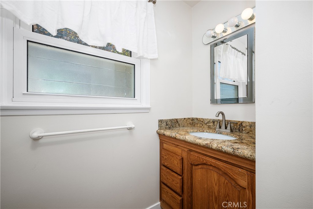 Full bath has been remodeled with a wooden vanity and granite counters. The large window brings in natural light and fre - 1200 Catalina Avenue, Seal Beach CA 90740 - photo 22
