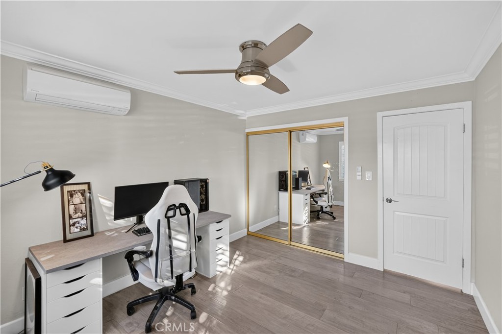 Guest Bedroom has mirrored closet, crown molding, and ceiling light/fan. - 12200 Montecito Road B112, Seal Beach CA 90740 - photo 13