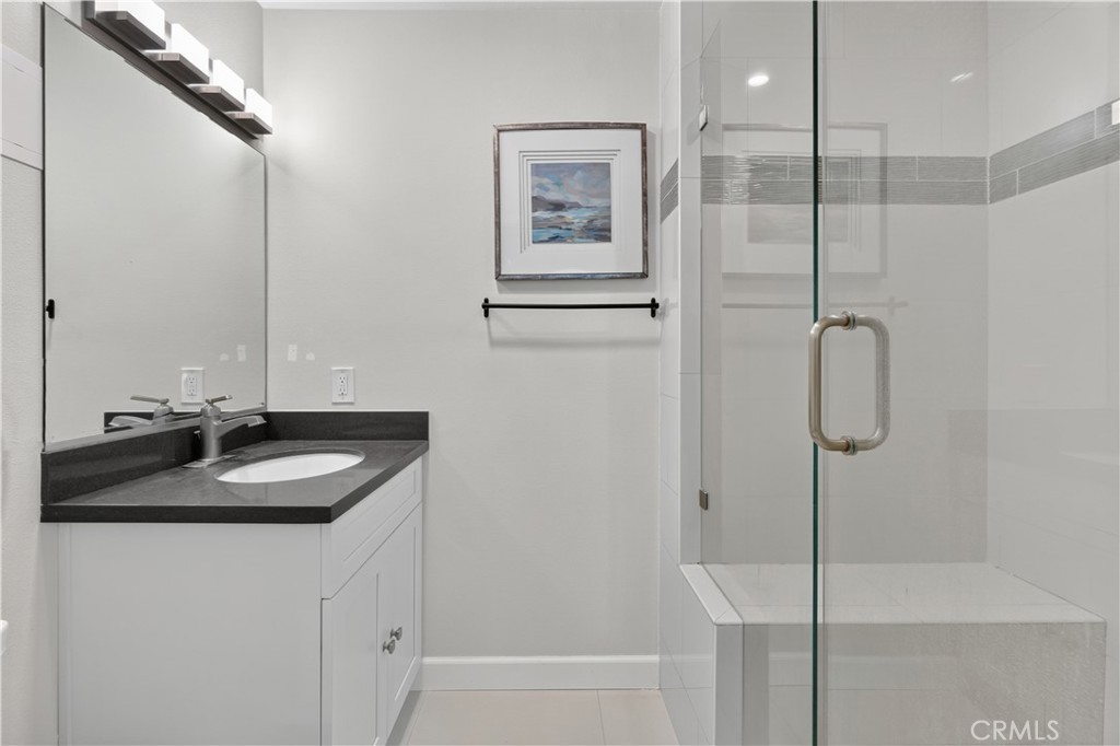 Primary Bedroom en suite has walk-in shower with frameless glass door and separate sink cabinet. - 12200 Montecito Road B112, Seal Beach CA 90740 - photo 18