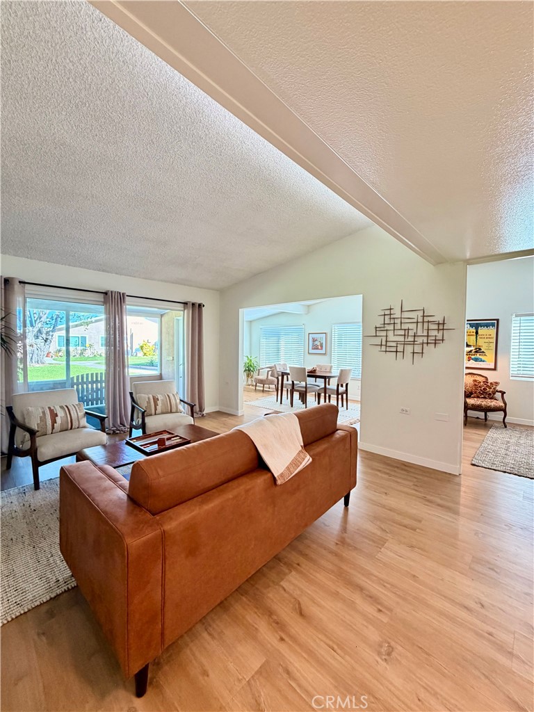 Bright living room featuring expansive windows and views of the surrounding grounds. - 13560 Medinac Lane 102 L, Seal Beach CA 90740 - photo 8