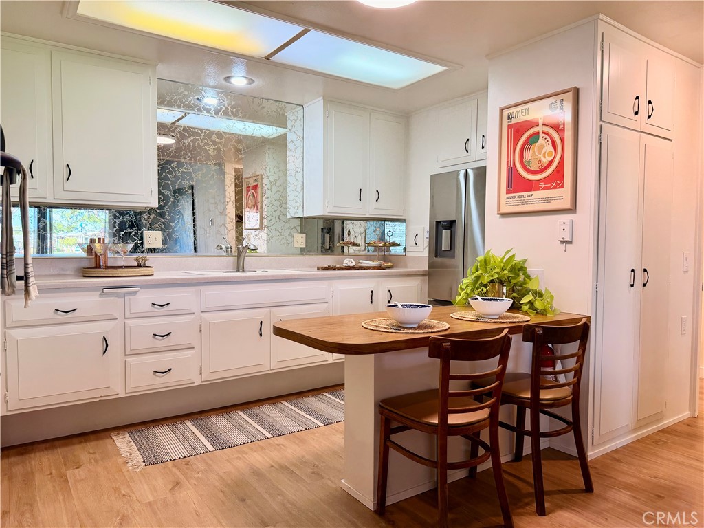 Spacious kitchen showcasing skylight illumination, extensive cabinetry, and functional workspace. - 13560 Medinac Lane 102 L, Seal Beach CA 90740 - photo 10