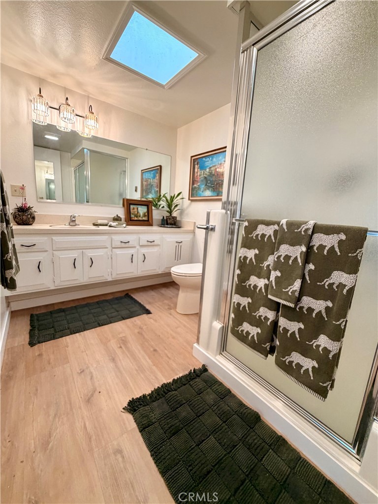 Bathroom featuring a walk-in shower, skylight and modern finishes. - 13560 Medinac Lane 102 L, Seal Beach CA 90740 - photo 13