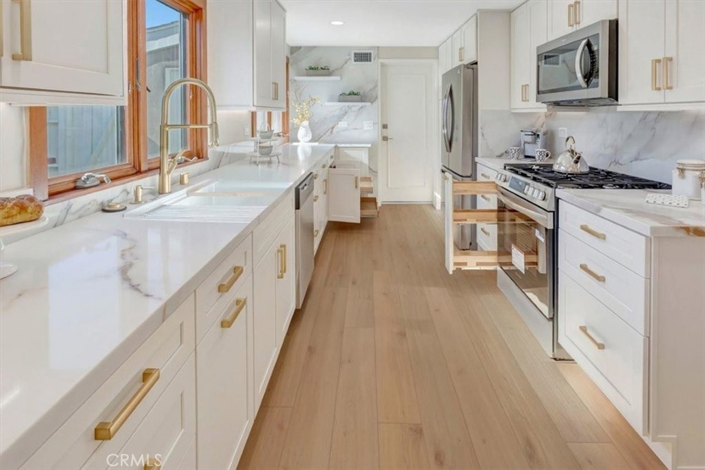 Notice spice rack adjacent stove, lower cabinet pullouts so​​‌​​​​‌​​‌‌​​‌‌​​‌‌​​‌​​​‌‌​‌​​​​‌‌​‌​​ convenient! - 14412 GRASSMERE, Tustin CA 92780 - photo 15
