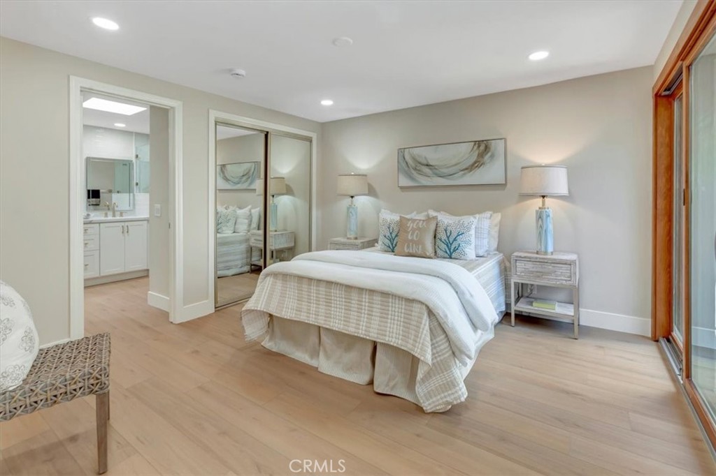 Primary bedroom opens to center atrium, lots of natural light and landscaping, mirrored wardrobes (2 primary closets) - 14412 GRASSMERE, Tustin CA 92780 - photo 16