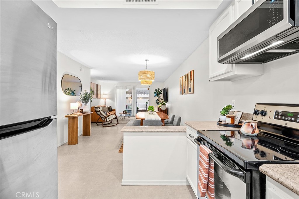Open layout connecting kitchen, dining and living areas - 1881 Mitchell Avenue 135, Tustin CA 92780 - photo 11
