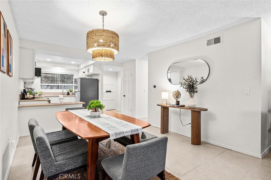 Dining area with open view into the kitchen. - 1881 Mitchell Avenue 135, Tustin CA 92780 - photo 14