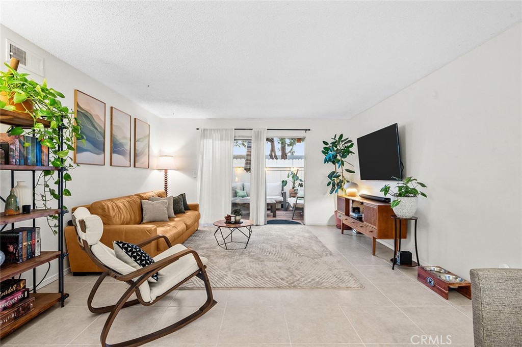 Spacious living room with direct access to the private patio. - 1881 Mitchell Avenue 135, Tustin CA 92780 - photo 15