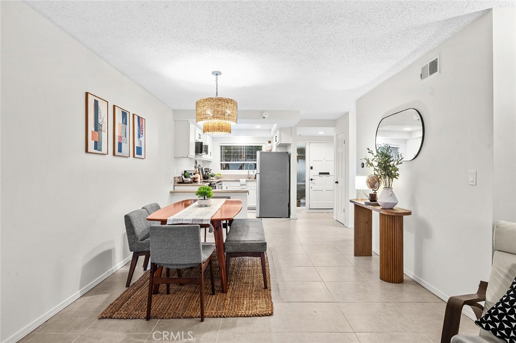Dining area with open view into the kitchen. - 1881 Mitchell Avenue 135, Tustin CA 92780 - photo 18