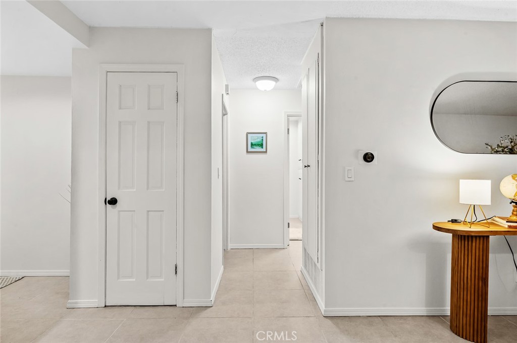 Interior hallway providing access to the bedrooms and living areas. - 1881 Mitchell Avenue 135, Tustin CA 92780 - photo 19