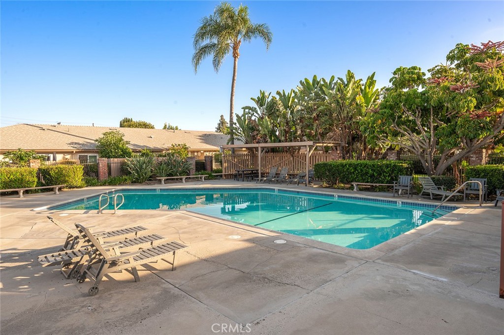 Community pool surrounded by mature landscaping, just a short walk from the home - 1881 Mitchell Avenue 135, Tustin CA 92780 - photo 36