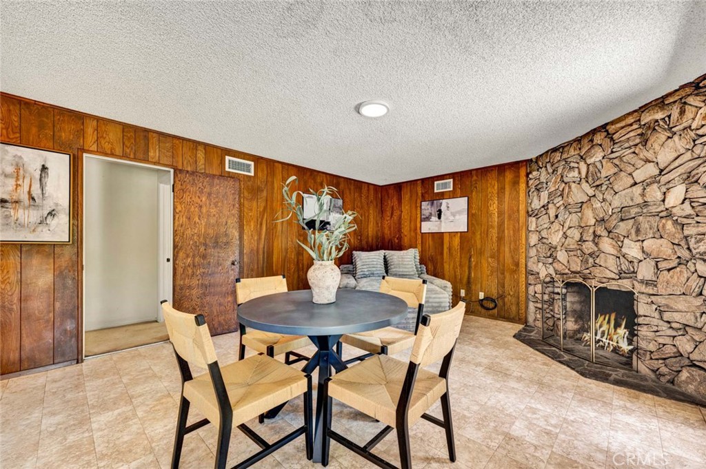 Family room shows rock fireplace wall and wood paneling. - 18381 Serrano, Villa Park CA 92861 - photo 30