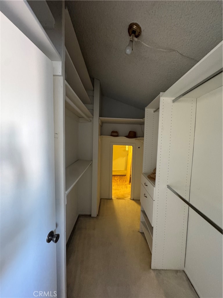 Main bedroom walk in closet with additional storage above the garage area - 14155 Elystan Circle, Westminster CA 92683 - photo 27