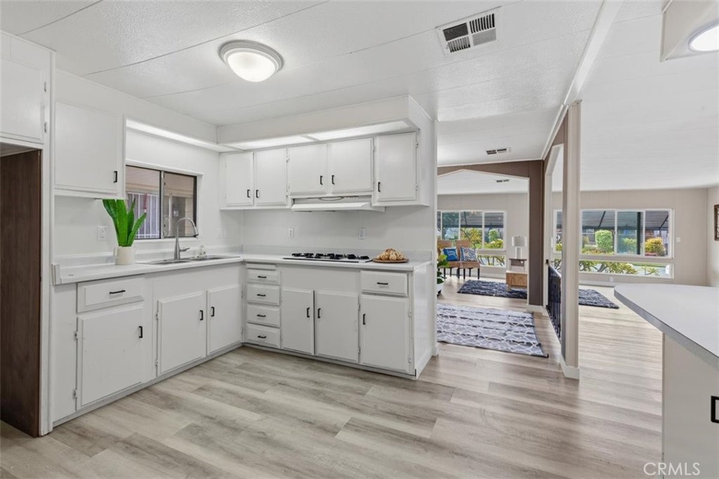 Kitchen with white cabinetry and gas range. - 15621 Beach Blvd 103, Westminster CA 92683 - photo 4