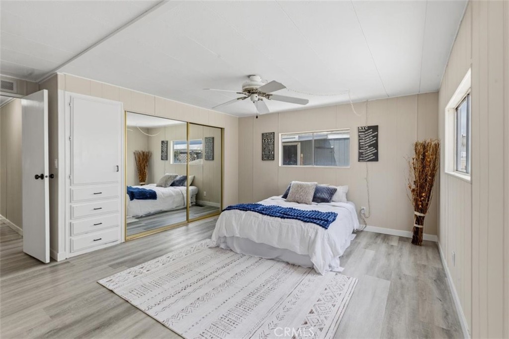 Spacious primary bedroom with mirrored closet doors. - 15621 Beach Blvd 103, Westminster CA 92683 - photo 13