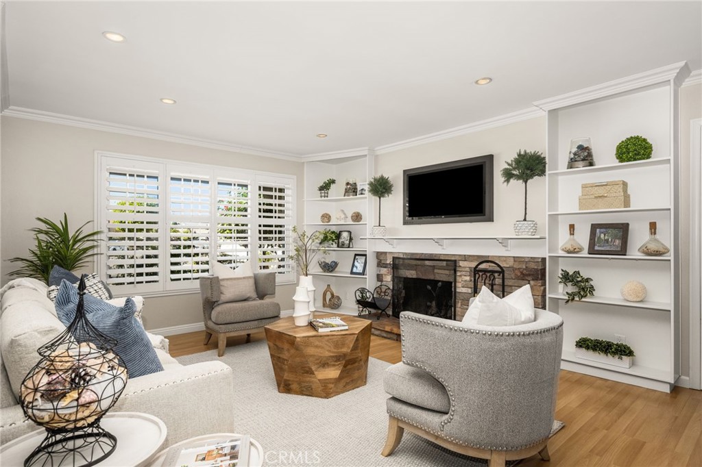 Living room with fireplace, built-ins and plantation shutters. - 8981 Blackheath Circle, Westminster CA 92683 - photo 8
