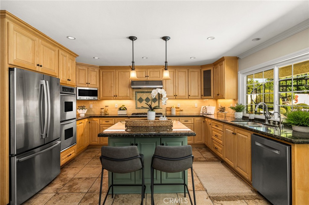 Kitchen with island seating and stainless steel appliances. - 8981 Blackheath Circle, Westminster CA 92683 - photo 10
