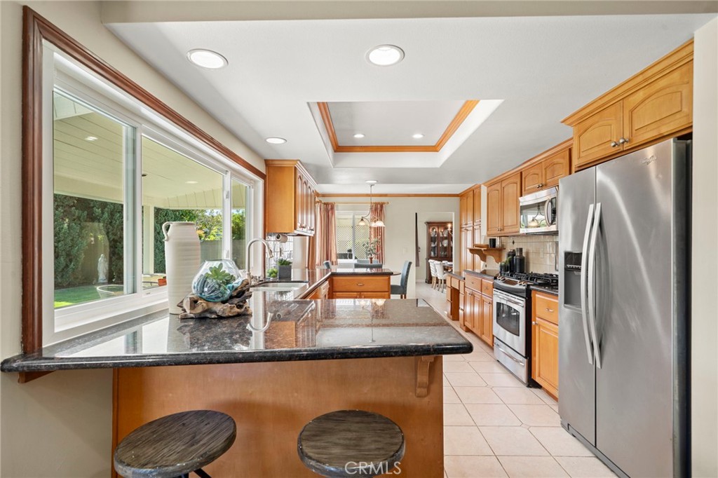 The sunlit kitchen showcases a coffered ceiling with recessed lighting, granite countertops, rich natural wood cabinetry - 9552 Westwood Drive, Westminster CA 92683 - photo 20