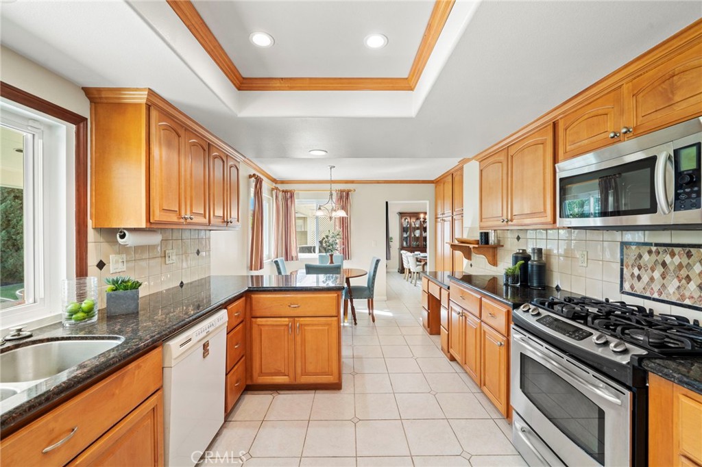 The sunlit kitchen showcases a coffered ceiling with recessed lighting, granite countertops, rich natural wood cabinetry - 9552 Westwood Drive, Westminster CA 92683 - photo 25